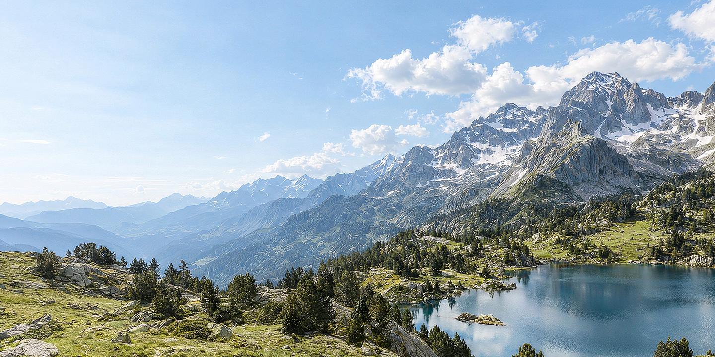Llac d’alta muntanya al peu de cims nevats, als Pirineus